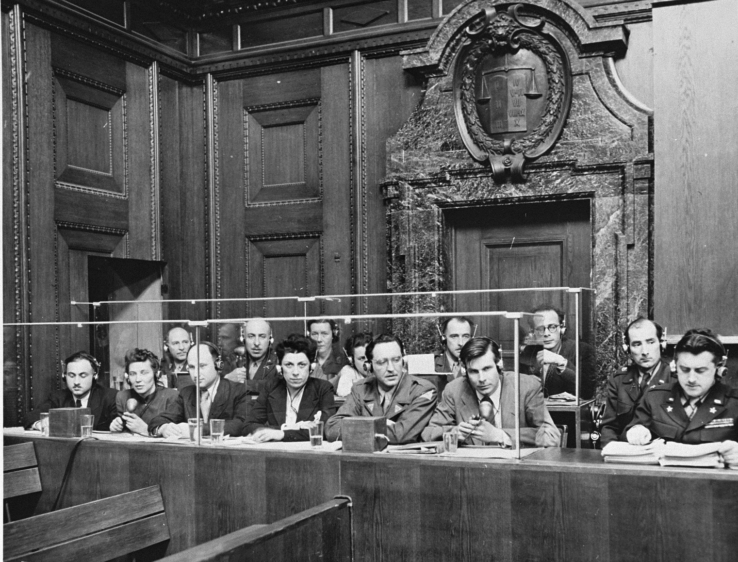 Léon Dostert (far right) at the Nuremberg trials, 1946. He had been Eisenhower's interpreter, invented the simultaneous-interpretation booth system still used at the United Nations, and in 1954 staged the first public demonstration of machine translation. Public domain photo via Wikimedia Commons.